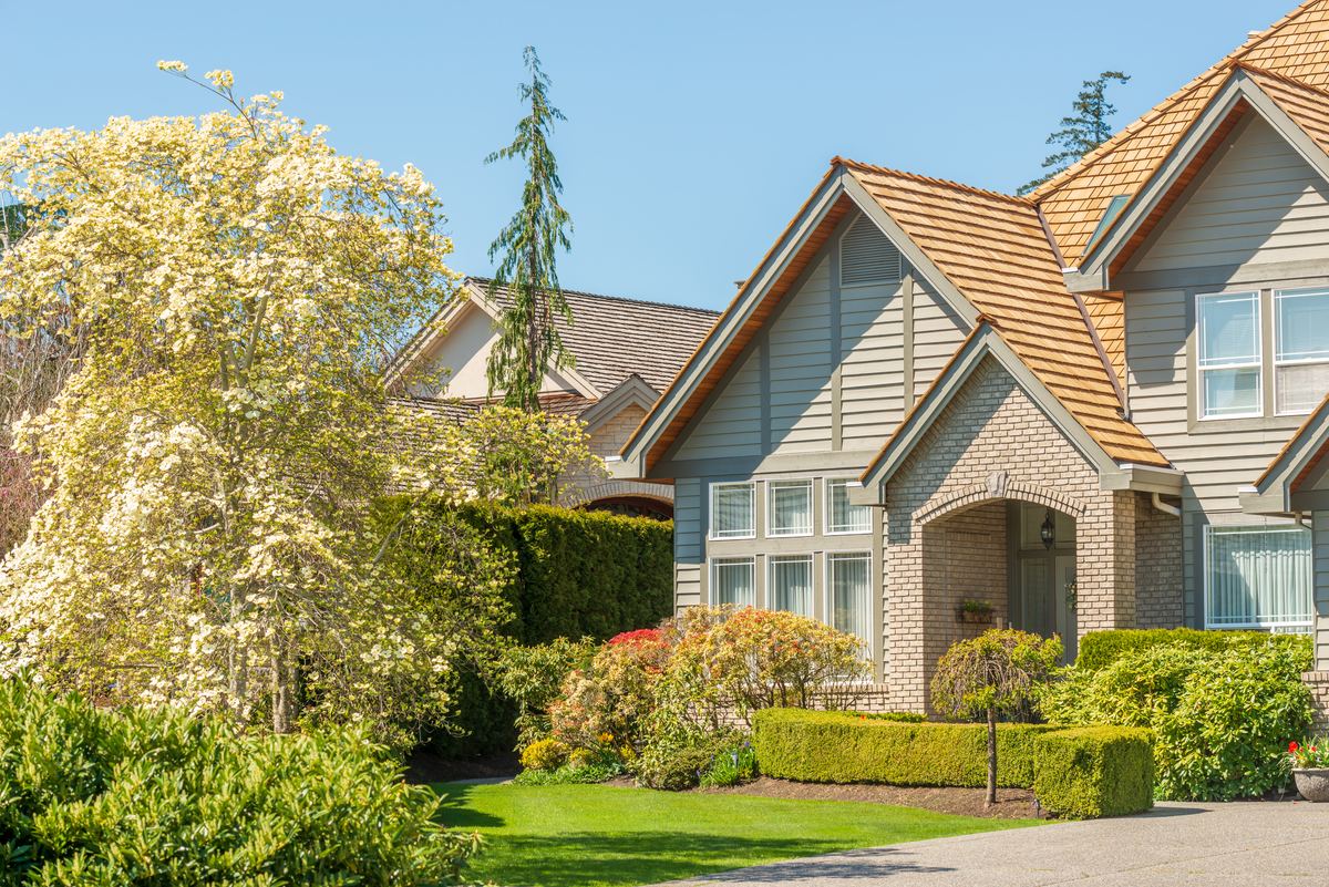 Newly built luxury home with clean gutters and manicured landscaping